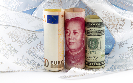 Euro currency of yuan, euro, and dollar reflections positive success of global networking and policy integration.  Money placed with white and blue ribbon and paper.の写真素材