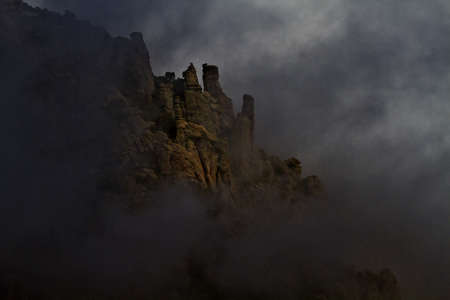 Dark clouds and shifting fog open to reveal rocky spires on Mount Lemmon in Tucson, Arizonaの写真素材