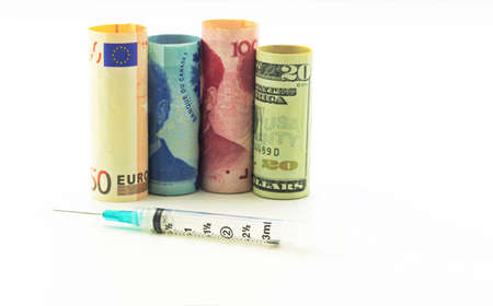 Collaborative development of global medical strategies conceptually visualized with four global currencies and syringe on white backgroundの写真素材