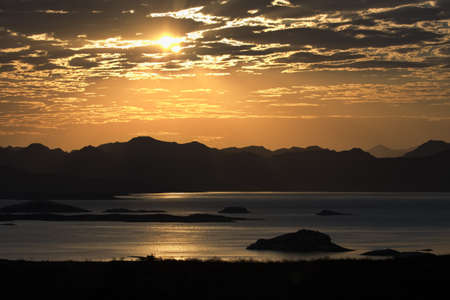 Golden glow of sunrise over Lake Mead, a reservoir in the striking landscape of Southwestern United Statesの写真素材