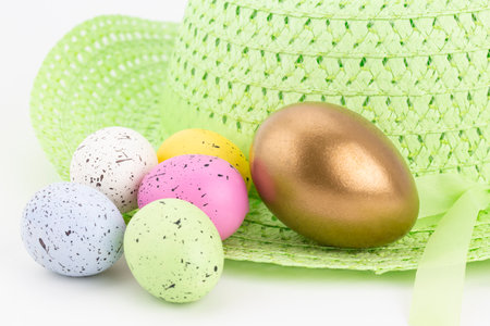 Differentiated successful investment  and financial win seen in larger gold nest egg among assorted pastel colored eggsの写真素材