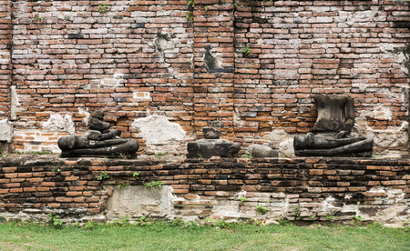 ruined buddha statue in ancient brick wall templeの写真素材