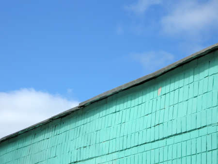 vintage green brick wall on blue sky with white clouds, colorful contrast construction conceptの写真素材