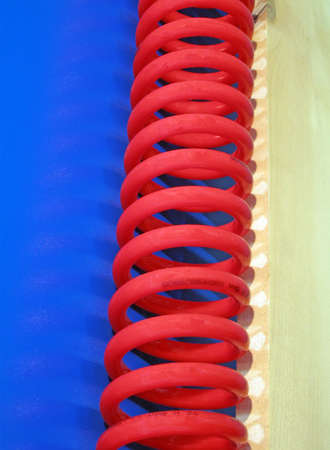 red curved cable  (elastic spring), blue surface. new industrial conceptの写真素材