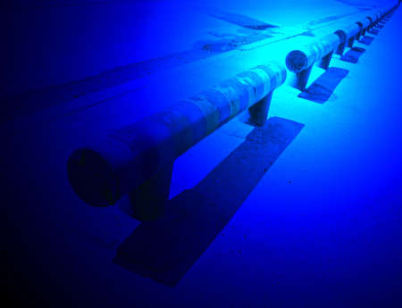 mystic blue light on road barier, hazard warning near asphalt roadの写真素材