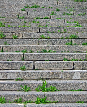 focus on center  stone staircase with green grass between granite stones, construction detailsの写真素材