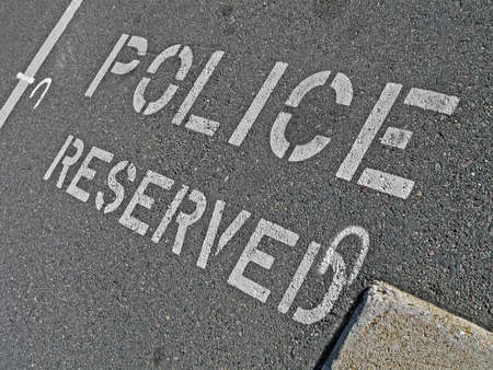 police reserved as white text on asphalt, security detailsの写真素材