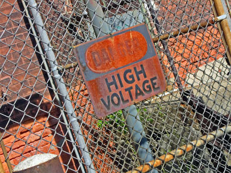 danger - high voltage as warning message on vintage rustical signboard, power detailsの写真素材