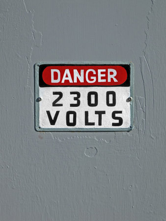 danger 2300 volt as text on grey vintage wooden wall, power detailsの写真素材