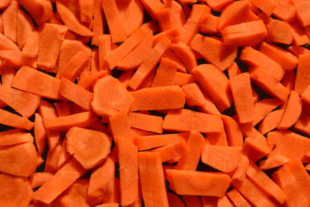 fresh orange carrots pieces pile, closeup texture detailsの写真素材