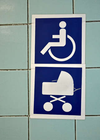 blue invalid wheelchair and pram sign on stone wall, security detailsの写真素材