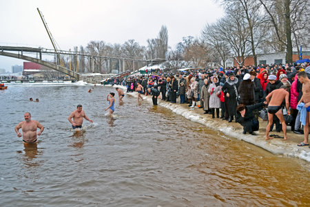 KIEV - JAN 19: Epiphany (Kreshchenya) morning in Hydropark on January 19, 2013 in Kiev, Ukraine. People plunging into ice-cold water three times as it helps body became more resilient to illness. Epiphany known since 988 AD.のeditorial素材
