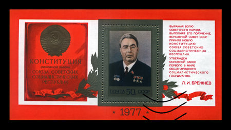 MOSCOW, USSR - CIRCA 1977: Leonid Brezhnev - politician leader of the Communist party of the Soviet Union, Constitution law of the USSR, circa 1977. Vintage stamp isolated on black background.のeditorial素材