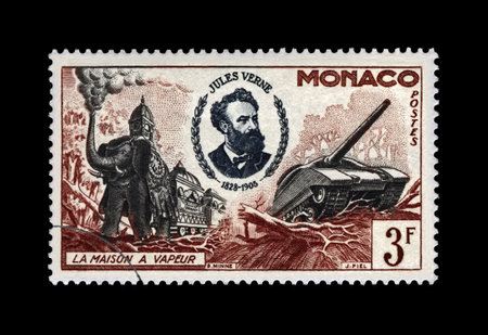 MONACO - CIRCA 1955: canceled postal stamp printed in Monaco shows Jules Verne (1828-1905), famous science writer and steam house, military machines, circa 1955. Vintage stamp isolated on black background.のeditorial素材
