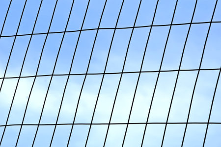 metal grid connections on blue sky, restricted prison area diversity