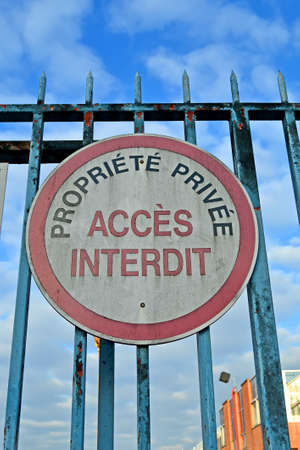 private property, forbidden access as text on french language on vintage metal fence affected by rust, restricted area diversityの写真素材
