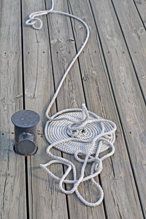 white skein rope heap closeup on vintage wooden surface (deck board), pier environment diversity