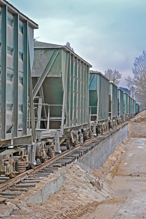 vintage cargo wagon train line with valve tap heap in nasty day, transportation technology diversity