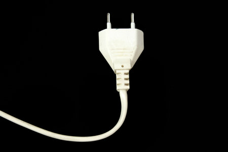 unplugged small power plug isolated over black