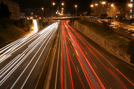 overview of a highway at night with multiple light streaks