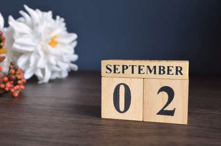 September 2, Date cover design with calendar cube and white Paeonia flower on wooden table and blue background.の写真素材