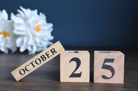 October 25, Date cover design with calendar cube and white Paeonia flower on wooden table and blue background.の写真素材