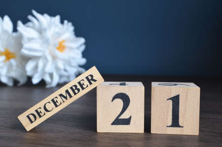 December 21, Date cover design with calendar cube and white Paeonia flower on wooden table and blue background.の写真素材