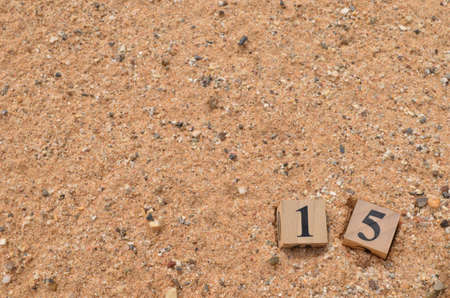 Number 15, rating, award, Empty cover design in natural concept with a number cube on sand background.の写真素材