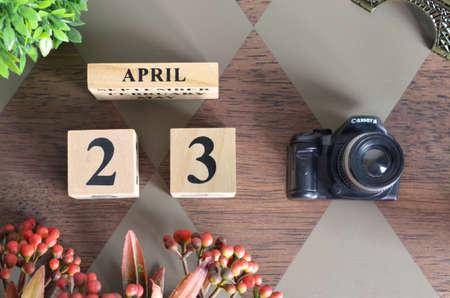 April 23, Date design with Number cube, a flower and camera on Diamond wood background.の写真素材