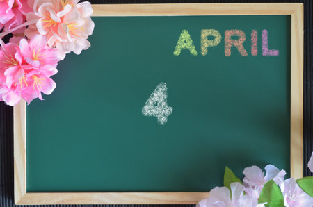 April 4, month write with colorful chalk, flowers on the board.の写真素材