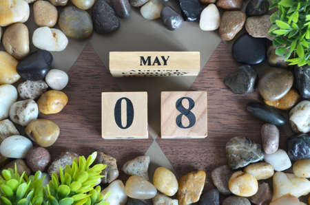 May 8, Number cube design with stone, plant on Diamon wood background.の写真素材