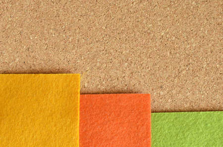 Orange green and yellow felt fabric on the brown recycle board.の写真素材