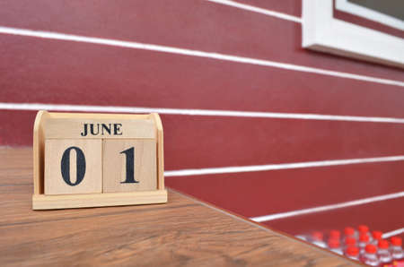 June 1, Number cube with wooden table beside the wall.の写真素材