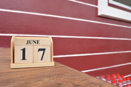 June 17, Number cube with wooden table beside the wall.の写真素材
