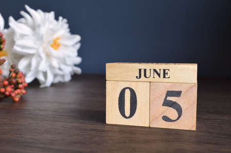 June 5, Date cover design with calendar cube and white Paeonia flower on wooden table and blue background.の写真素材