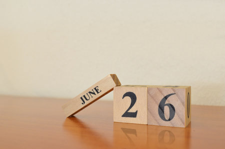 June 26, Date design with calendar cube on wooden table and white background.の写真素材