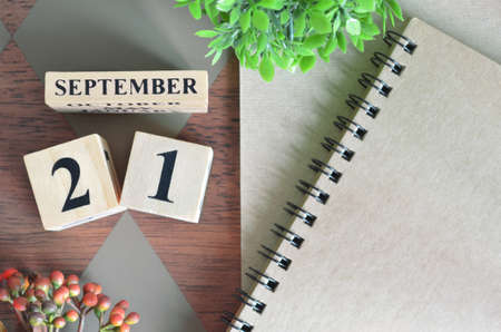 September 21. Date of September month. Number Cube with a flower and notebook on Diamond wood table for the background.の写真素材