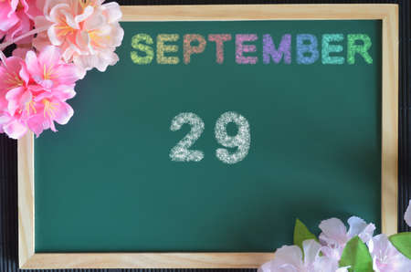 September 29, month write with colorful chalk, flowers on the green board.の写真素材