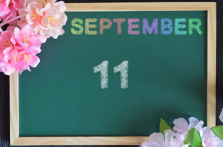 September 11, month write with colorful chalk, flowers on the green board.の写真素材