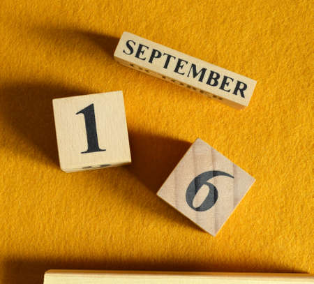 September 16, Wooden Calendar cube on yellow felt fabric for date icon background.の写真素材