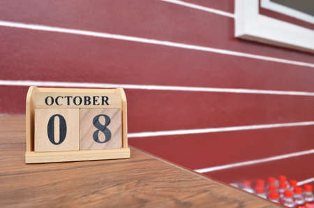 October 8, Number cube with a wooden table beside the wall.の写真素材