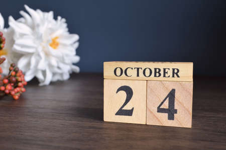 October 24, Date cover design with calendar cube and white Paeonia flower on wooden table and blue background.の写真素材