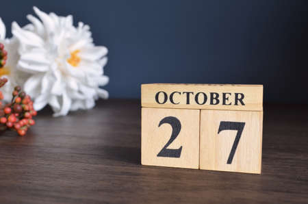 October 27, Date cover design with calendar cube and white Paeonia flower on wooden table and blue background.の写真素材