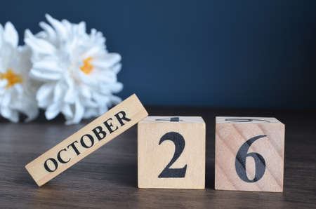 October 26, Date cover design with calendar cube and white Paeonia flower on wooden table and blue background.の写真素材