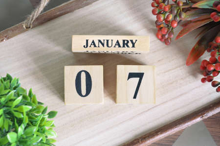 January 7. Date of January month. Number Cube with a flower and Sign wood on the Diamond wood table for the background.の写真素材
