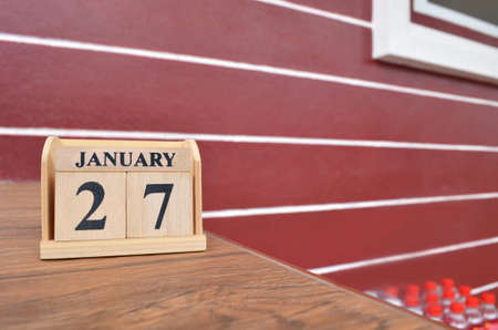 January 27, Number cube with a wooden table beside the wall.の写真素材