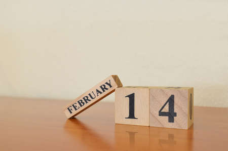 February 14, Date design with calendar cube on wooden table and white background.の写真素材