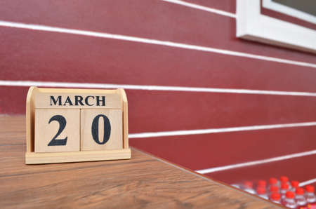 March 20, Number cube with wooden table beside the wall.の写真素材