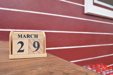 March 29, Number cube with wooden table beside the wall.の写真素材