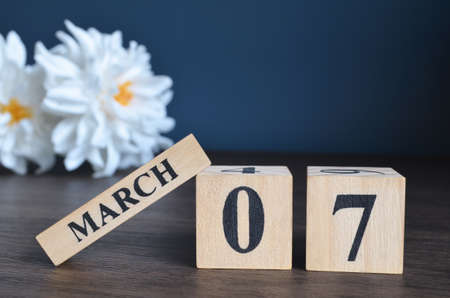 March 7, Date cover design with calendar cube and white Paeonia flower on wooden table and blue background.の写真素材